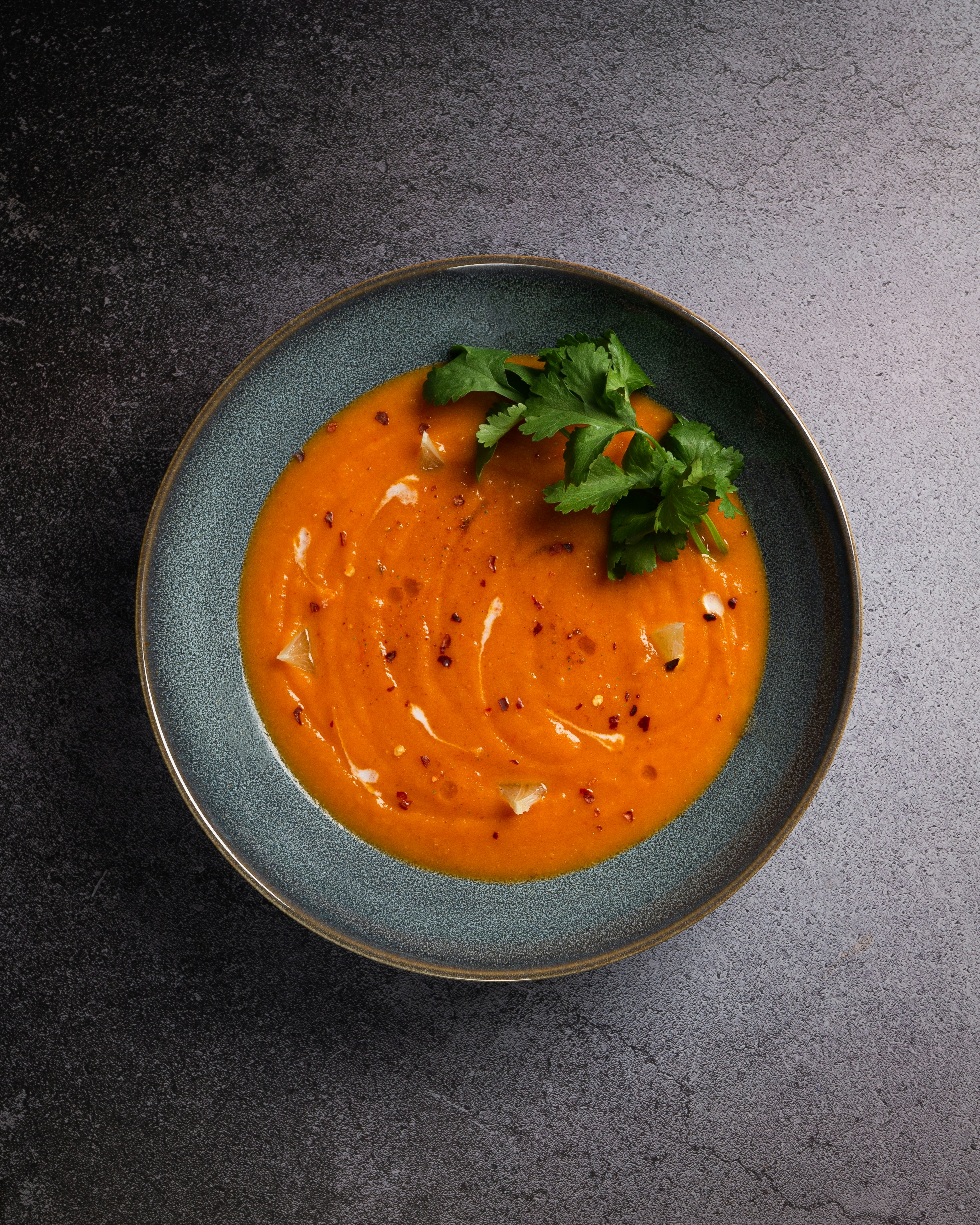 Creamy high protein marinara sauce in a bowl with herbs and chili flakes