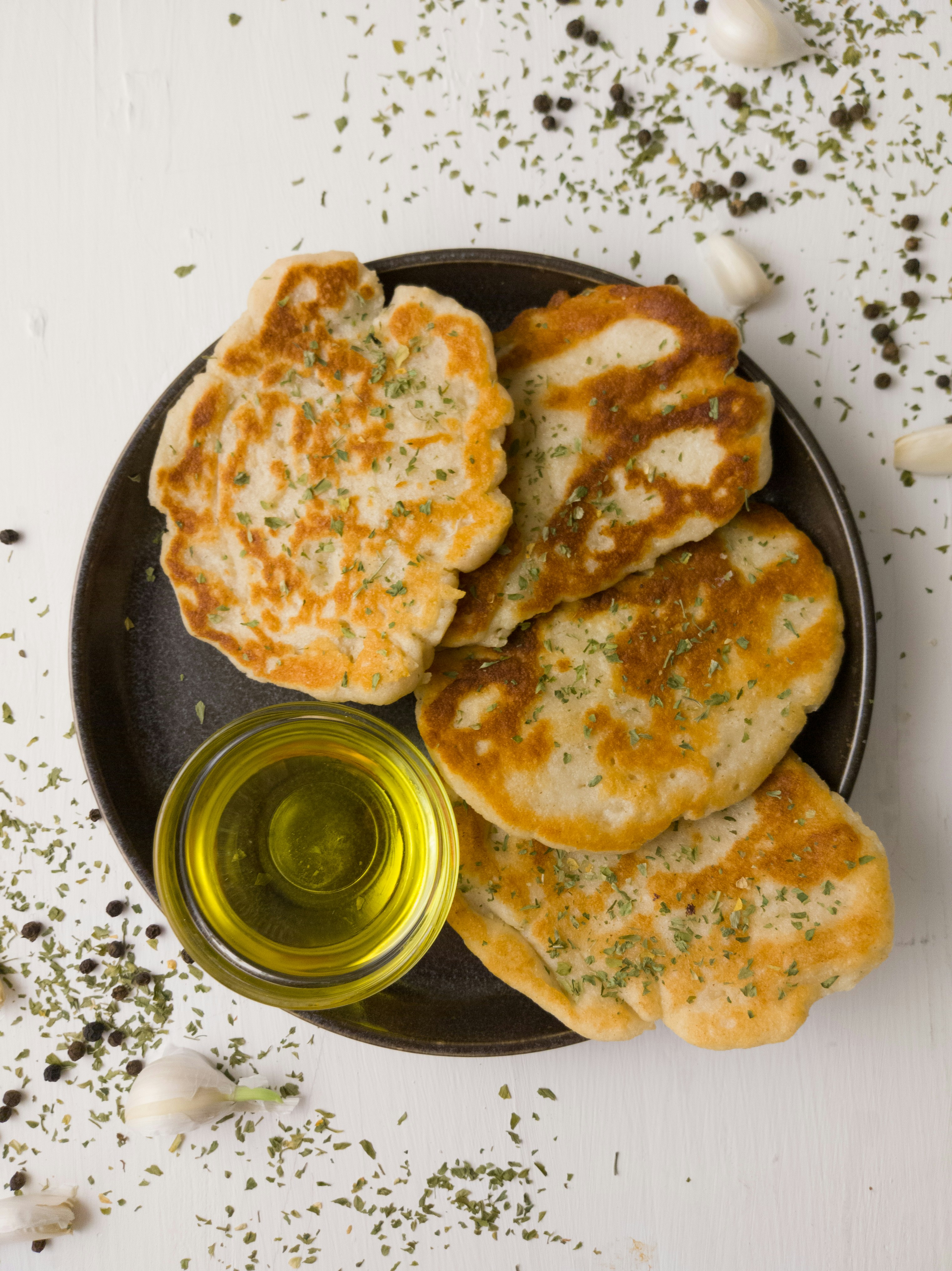 Golden pan-fried garlic naan brushed with garlic butter and parsley