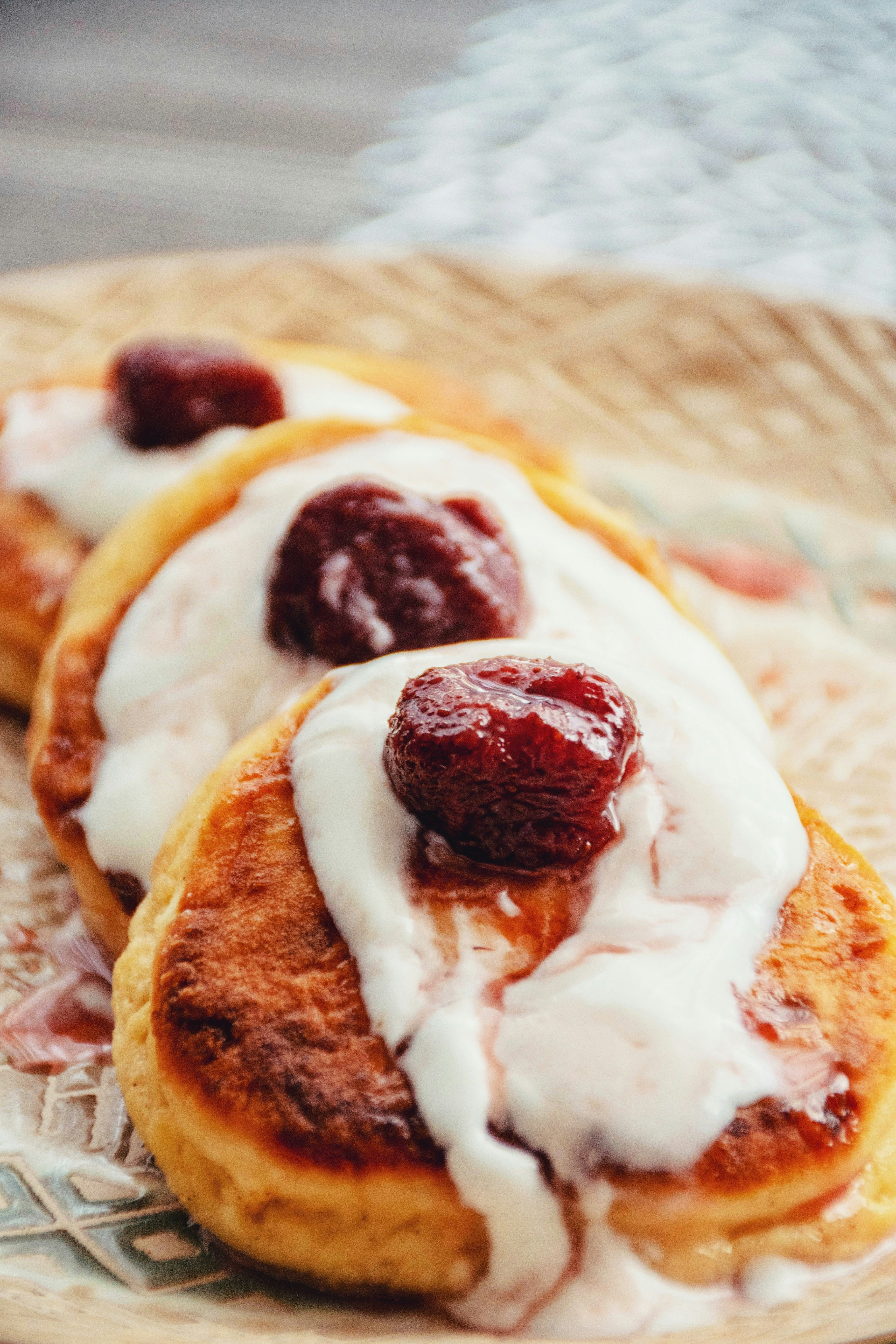 Stack of raspberry protein pancakes topped with lemon cream cheese frosting